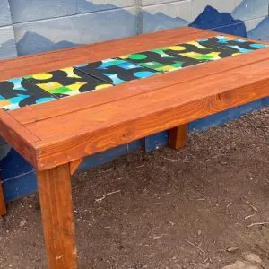 Outdoor Dining Table with Green, Yellow, Blue Snowboards Runner