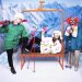 Orange ski lift bench used as a party photo booth prop with three people in ski gear