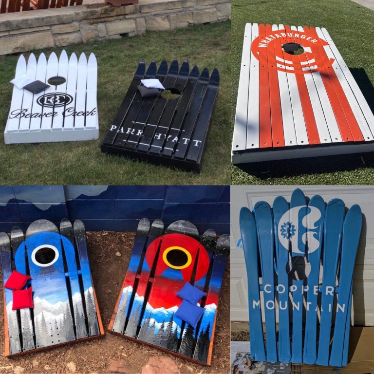 Ski cornhole board sets carrying resort and restaurant logos plus a painted mountain sunset pair