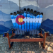 Front view of a 62 inch ski rocker bench with the Colorado flag painted over snowcapped peaks and pines
