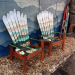 Pair of green mountain mural ski chairs angled in front of a painted mountain wall in Manitou Springs