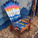 Angled view of a sunset and sunflower ski chair built from retired skis on a redwood stained base